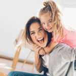 Young woman and small girl having a great time together